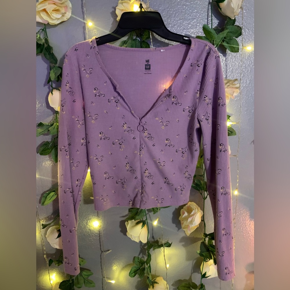Purple long sleeve top with black yellow and white flowers on it